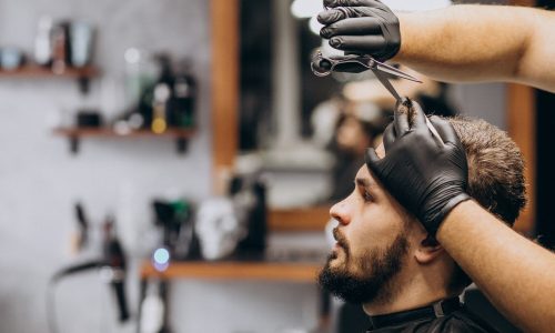 cliente-facendo-taglio-di-capelli-in-un-salone-di-barbiere_1303-20735