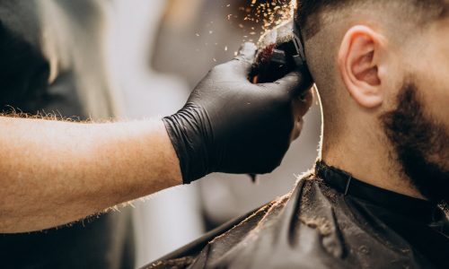 cliente-facendo-taglio-di-capelli-in-un-salone-di-barbiere_1303-20787