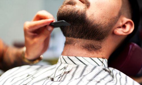 parrucchiere-che-pettina-la-barba-del-cliente_23-2148256922