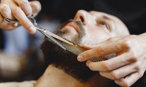 uomo-con-la-barba-parrucchiere-con-un-cliente-uomo-con-un-pettine-e-delle-forbici_1157-43566