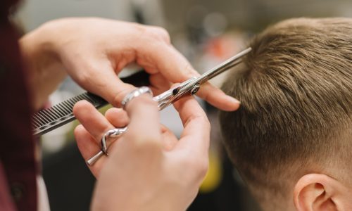 vista-del-primo-piano-dell-uomo-che-ottiene-un-taglio-di-capelli_23-2148506231